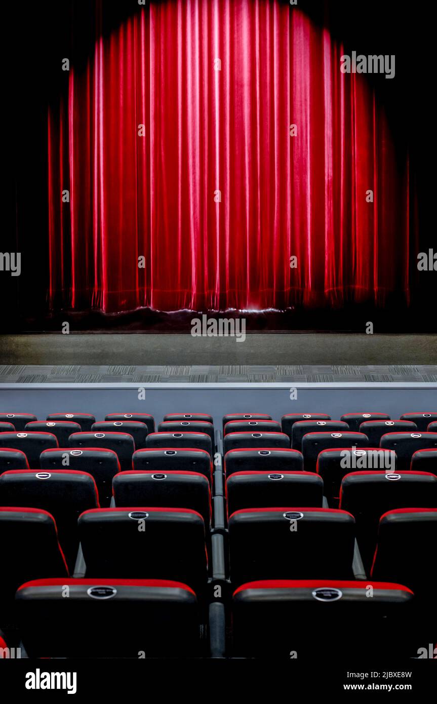 Riflettori luminosi sulle tende del palco nel teatro Foto Stock