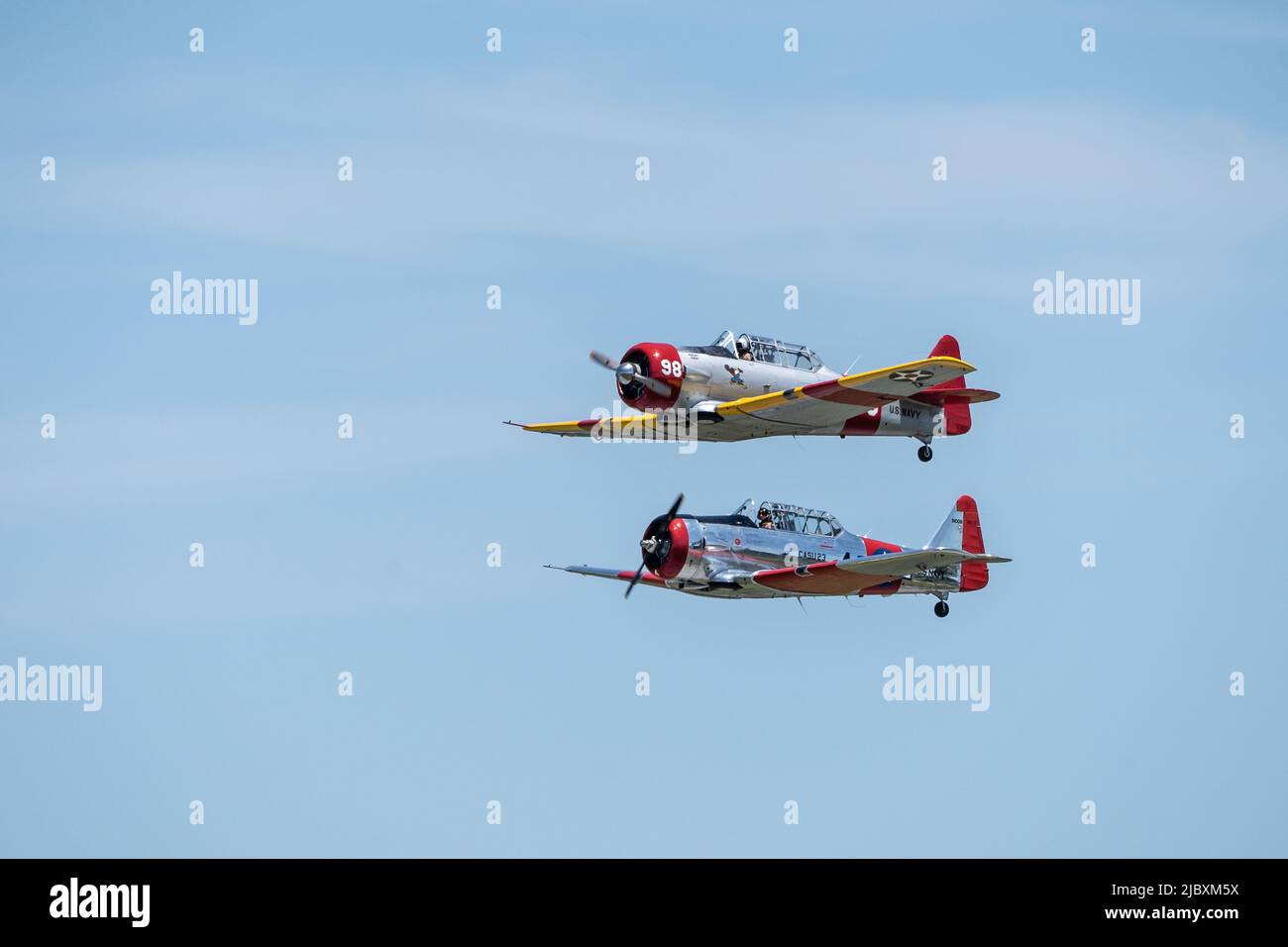 Reading, Pennsylvania, USA-6 giugno 2022: Quattro aeroplani della seconda guerra mondiale che trailano il fumo fanno un volo contro uno sfondo blu del cielo durante il Mid-Atlantic Museum WW Foto Stock