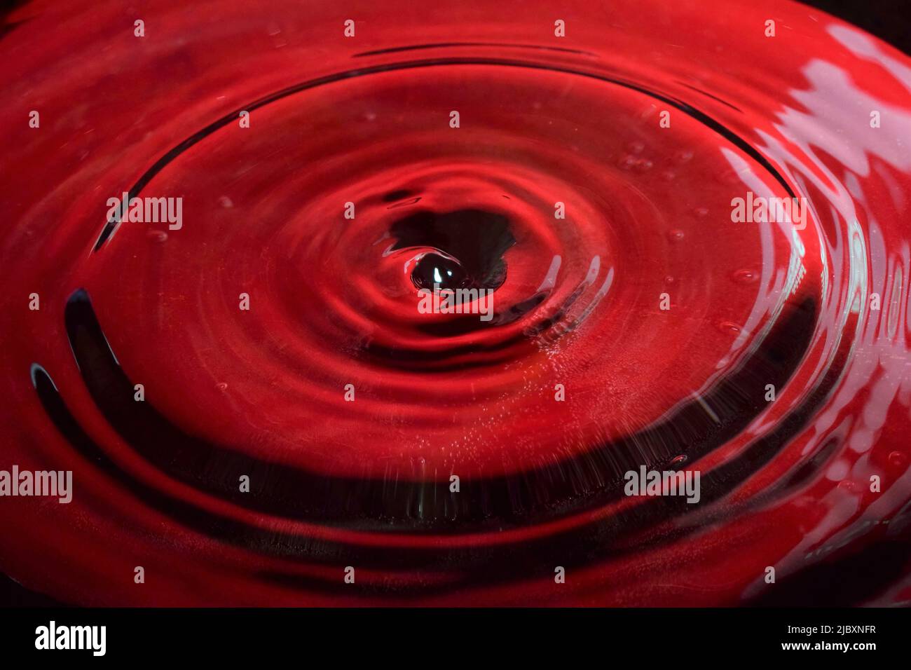 Foto delle gocce d'acqua, da vicino con sfondo rosso Foto Stock