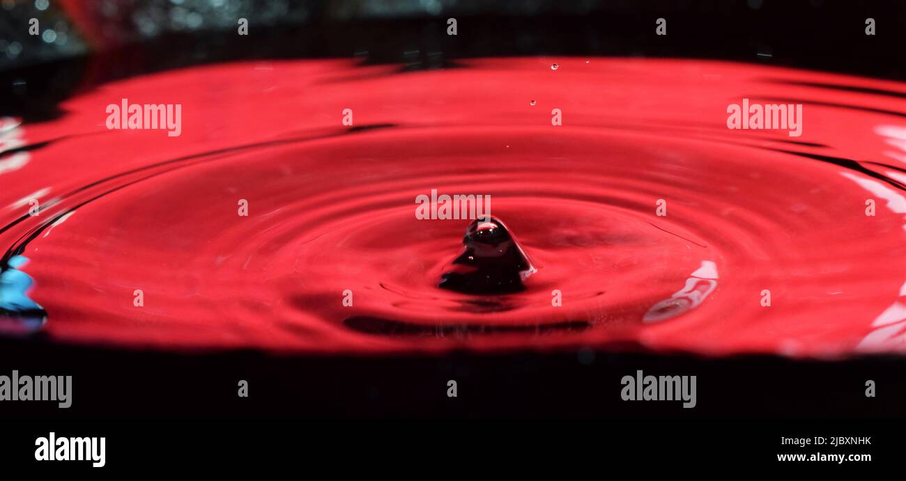 Foto delle gocce d'acqua, da vicino con sfondo rosso Foto Stock