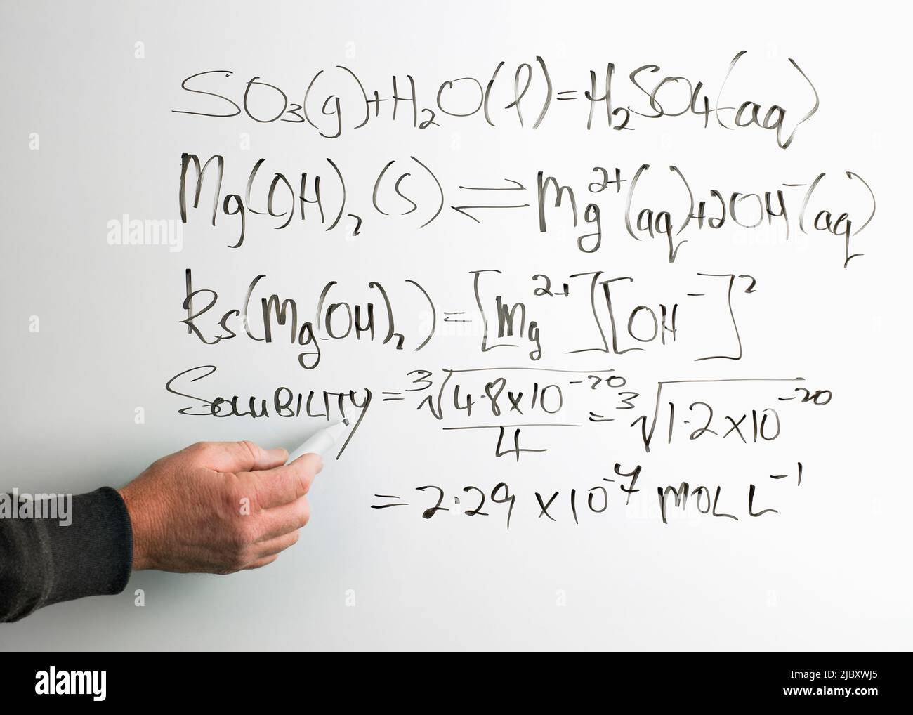 Mans scrivere a mano equazione matematica sulla lavagna Foto Stock