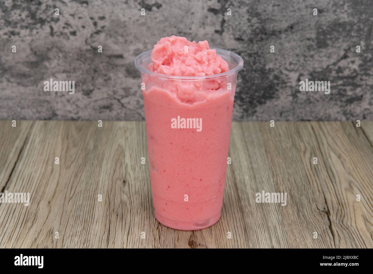 Gustosa bevanda a base di fragole mescolata in una tazza alta e ghiacciata per quell'appetito assetato. Foto Stock