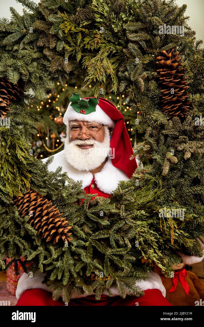 Uomo nero afroamericano in costume di Babbo Natale sorridente alla macchina fotografica. Foto Stock