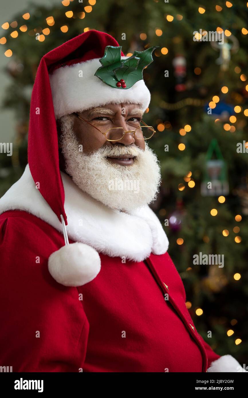 Ritratto scuro di un uomo nero afroamericano vestito come Babbo Natale Foto Stock