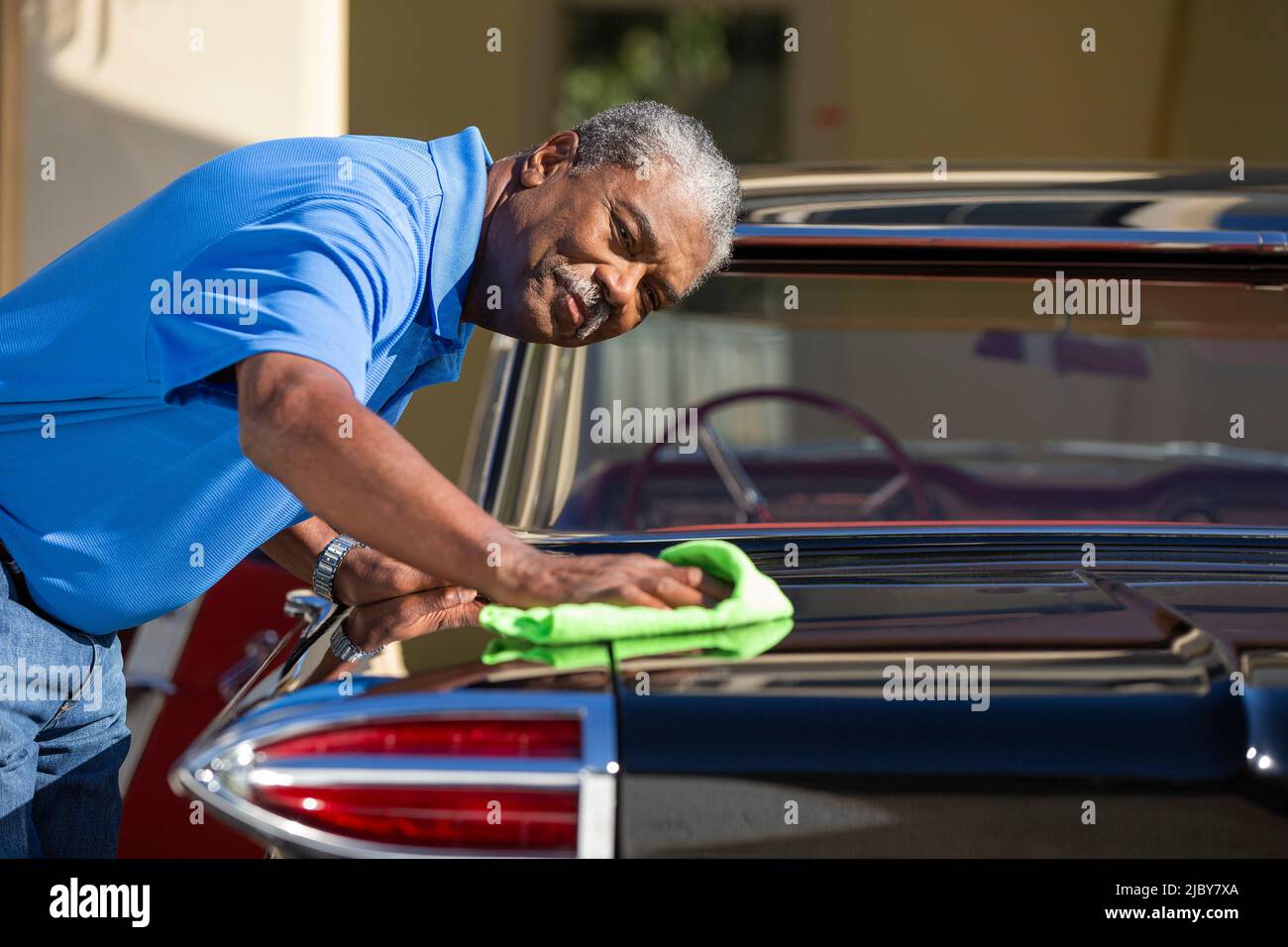 Uomo anziano che asciuga la sua auto classica Foto Stock