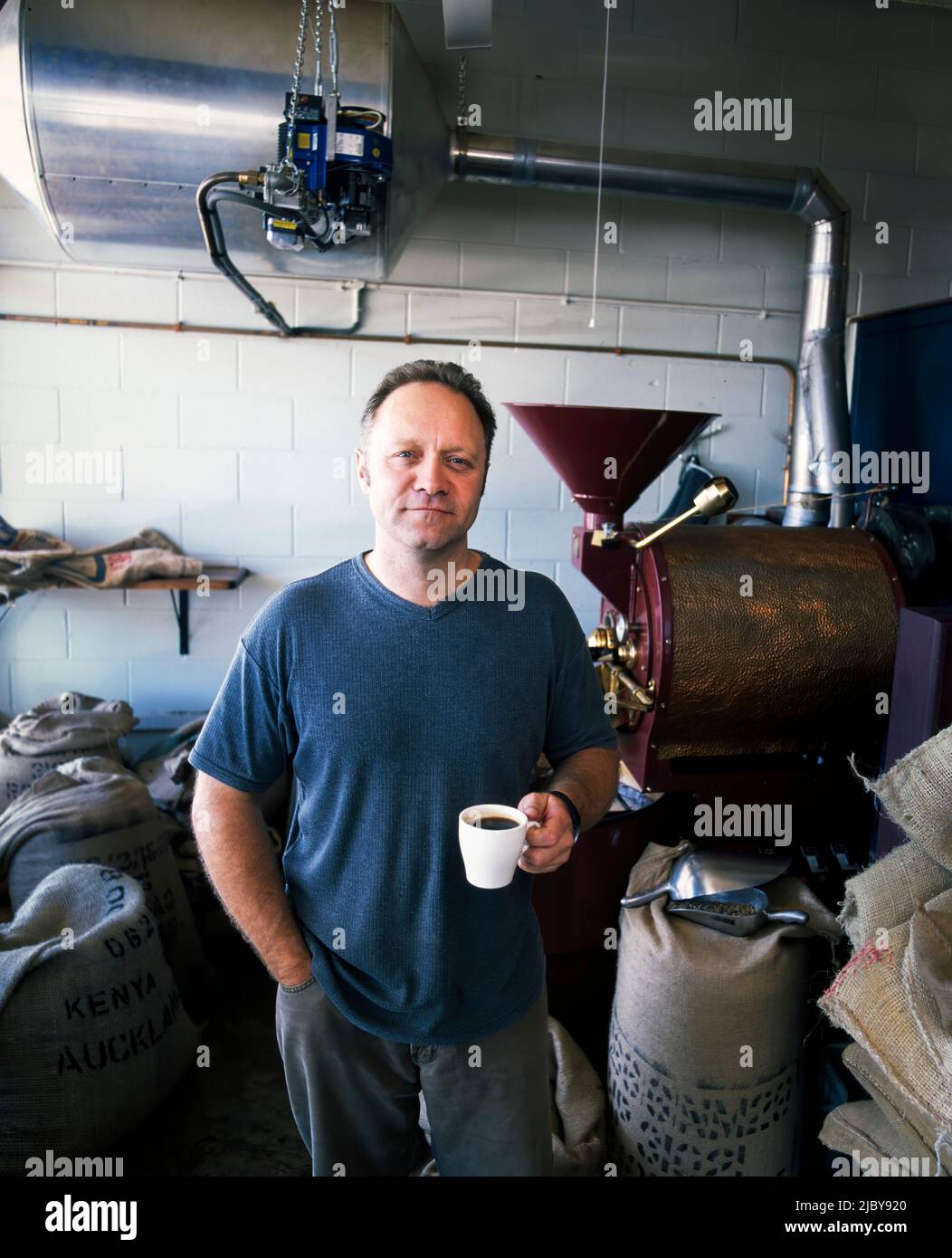Ritratto di caffè master tostatore degustazione tazza di caffè in sala tostatura Foto Stock