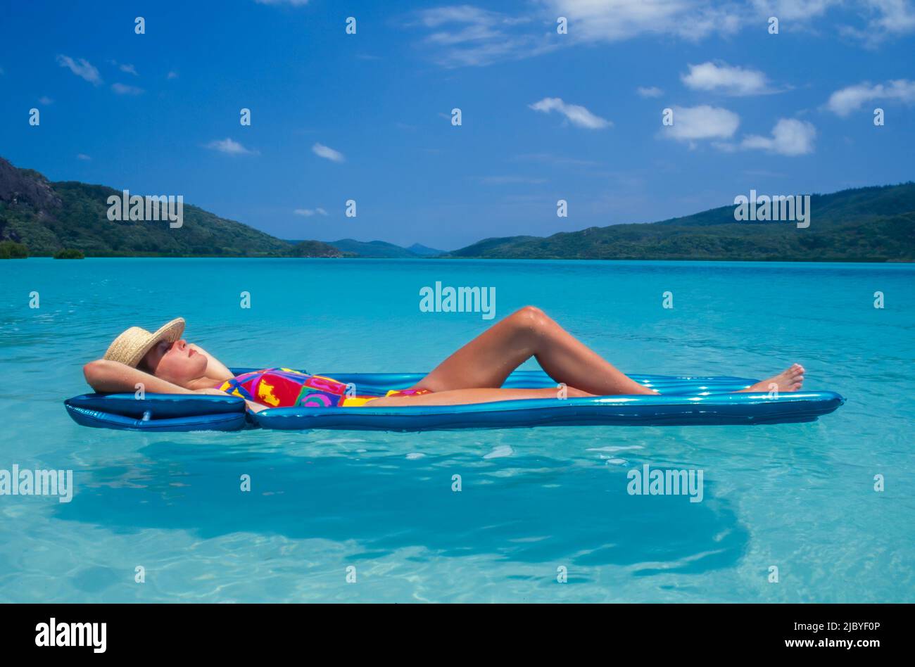 Giovane donna che galleggia su un LILO a Whitehaven Beach Foto Stock