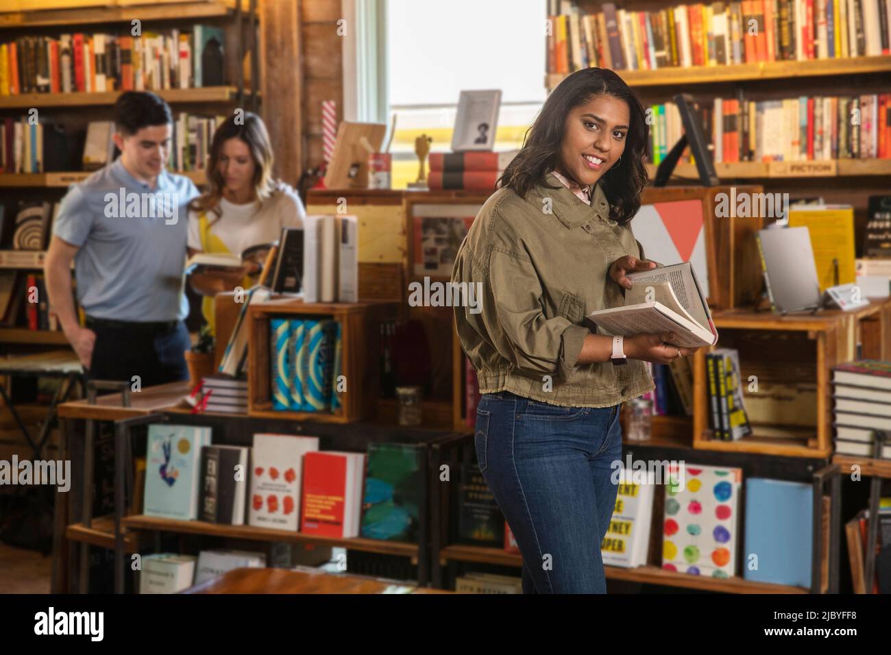 Ritratto di giovane donna che guarda in su dal libro di lettura in negozio di libri boutique Foto Stock