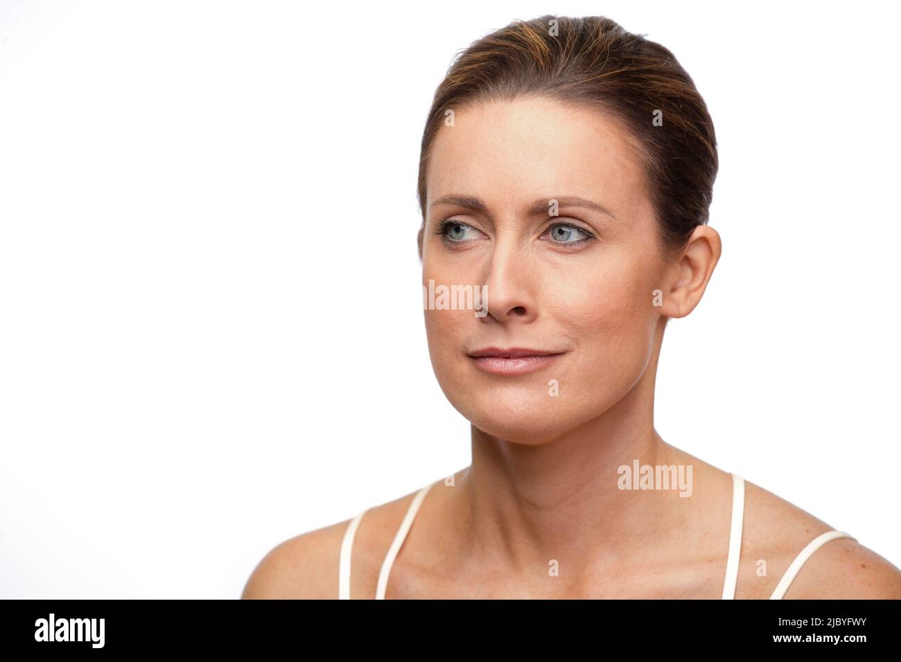 Ritratto di donna bianca di mezza età con capelli marroni tirati indietro, guardando fuori la fotocamera diritto di fronte Foto Stock
