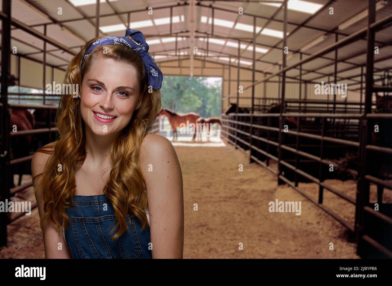 Donna sorridente in piedi nel fienile Foto Stock