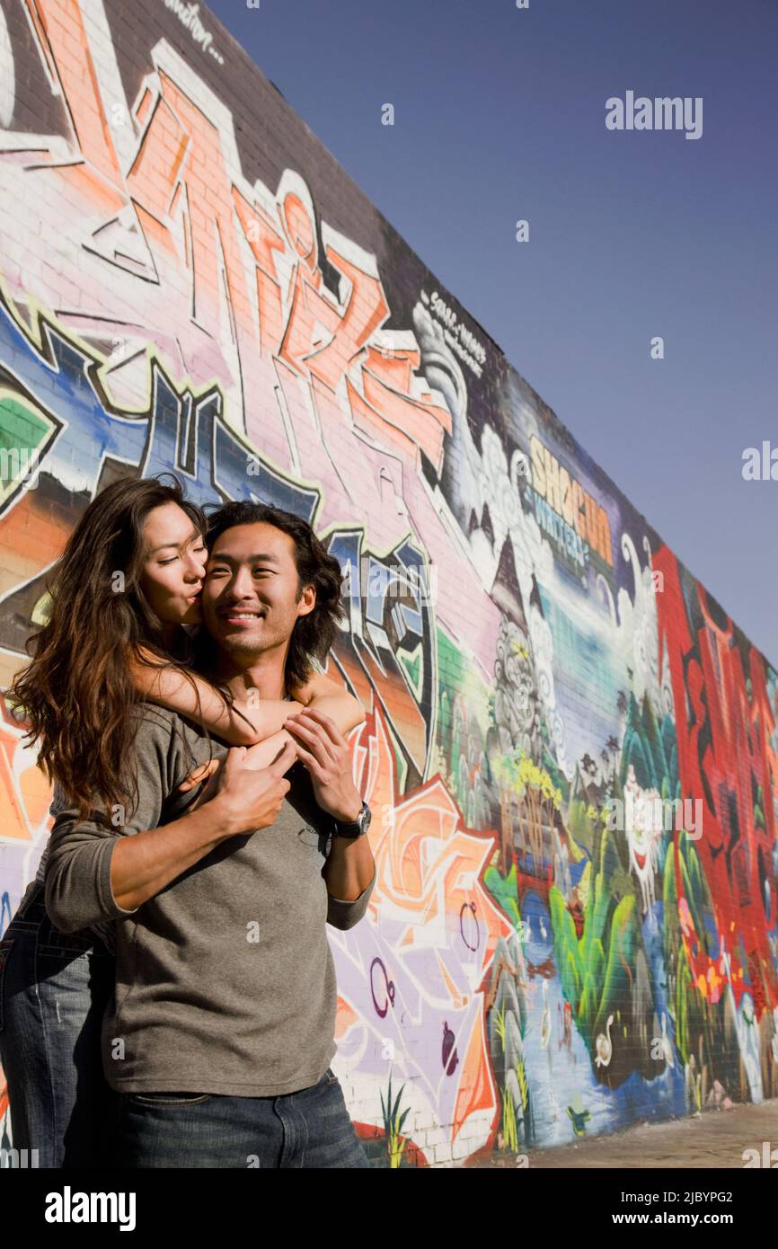 Il coreano giovane costeggiata vicino al muro di graffiti esterni Foto Stock