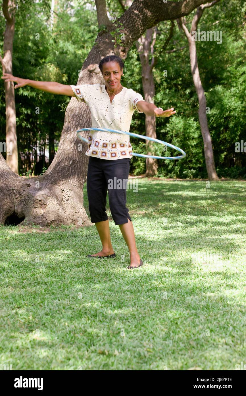 Donna africana anziana che gioca con l'anello di plastica Foto Stock