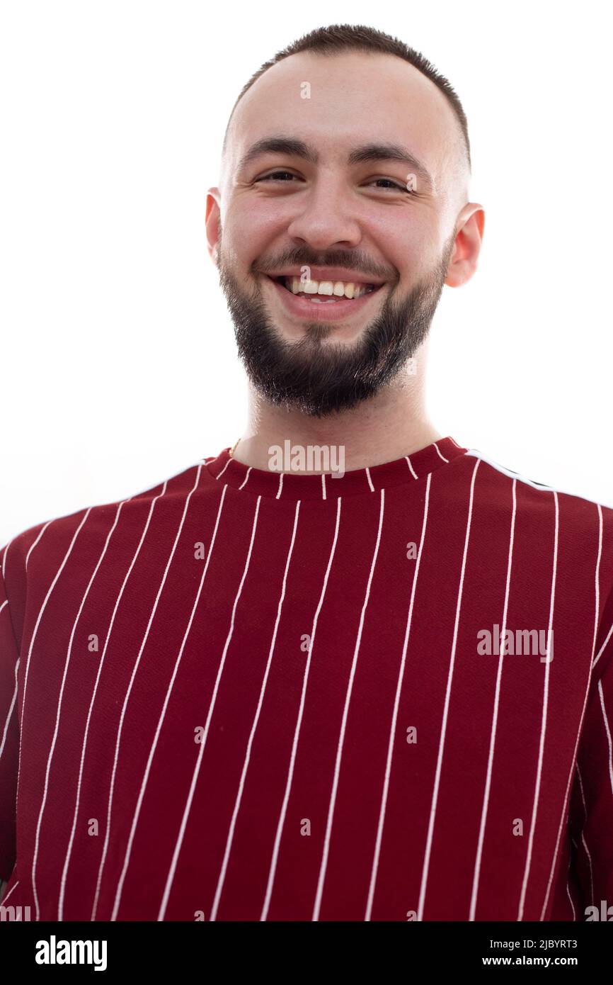 Primo piano immagine verticale del volto dell'uomo non rasato che si posa e guarda la fotocamera. Maschio con bel sorriso. Sbiancamento dei denti Foto Stock