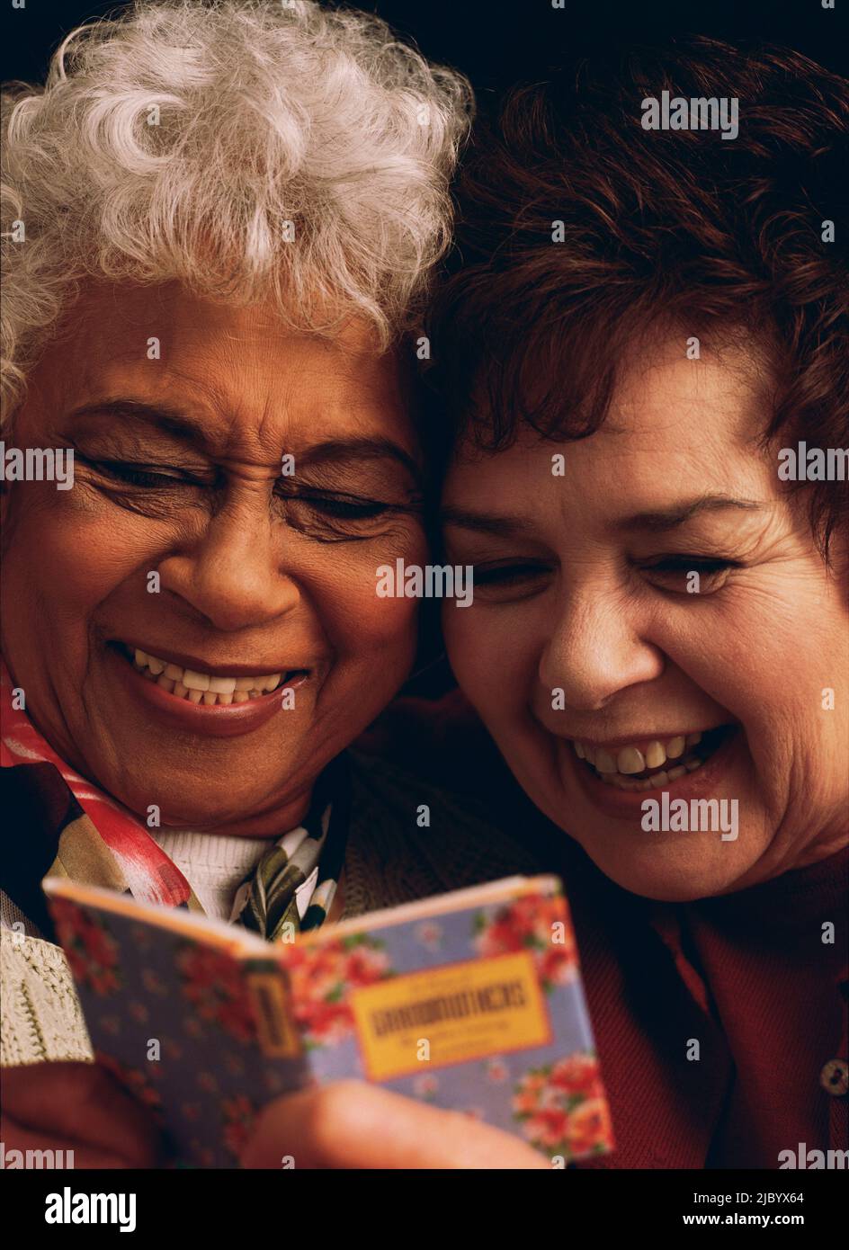 Le donne anziane la condivisione divertente libro insieme Foto Stock