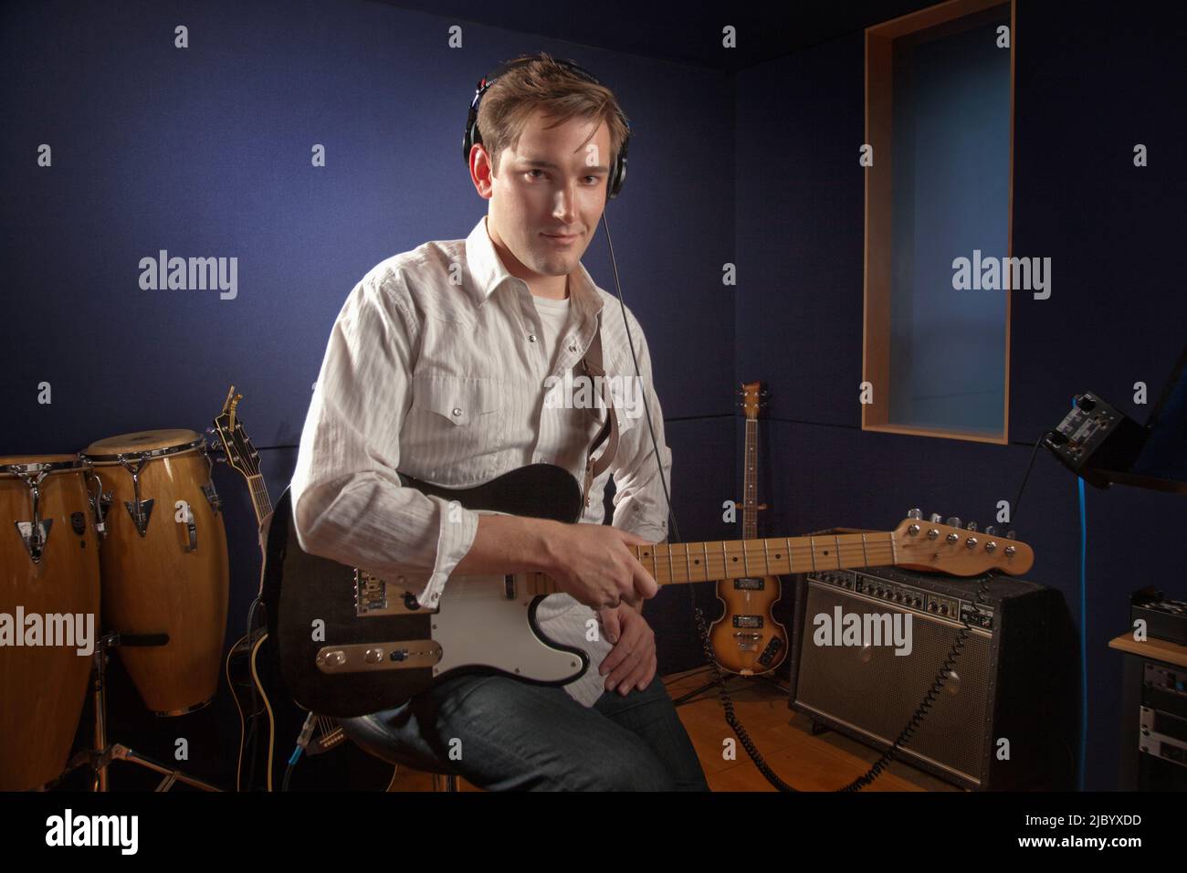 Uomo caucasico suonando la chitarra in studio Foto Stock