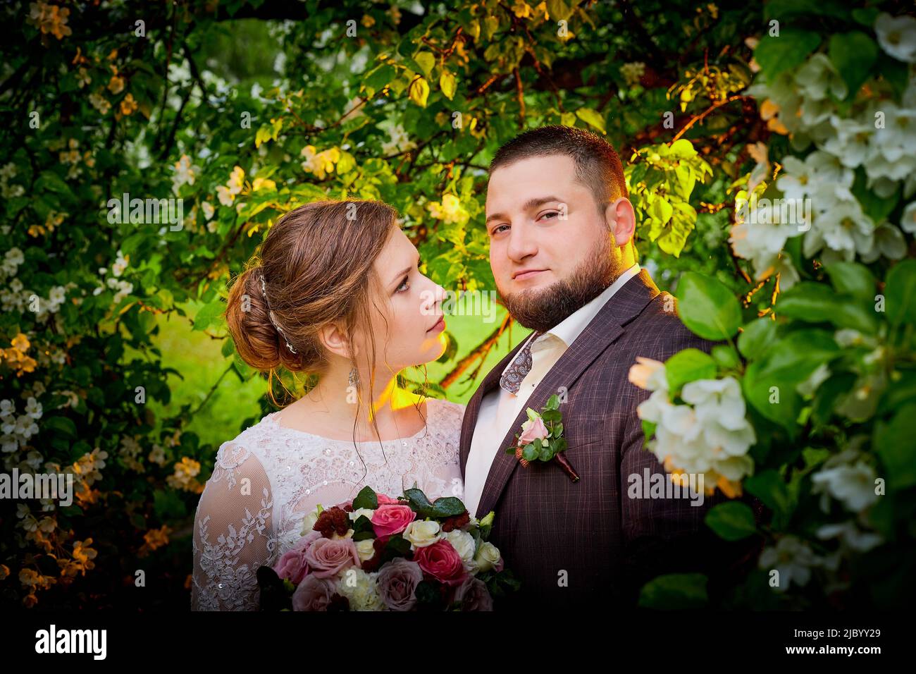 Concetto di matrimonio. Sposi e sposi nel parco verde in una giornata estiva Foto Stock