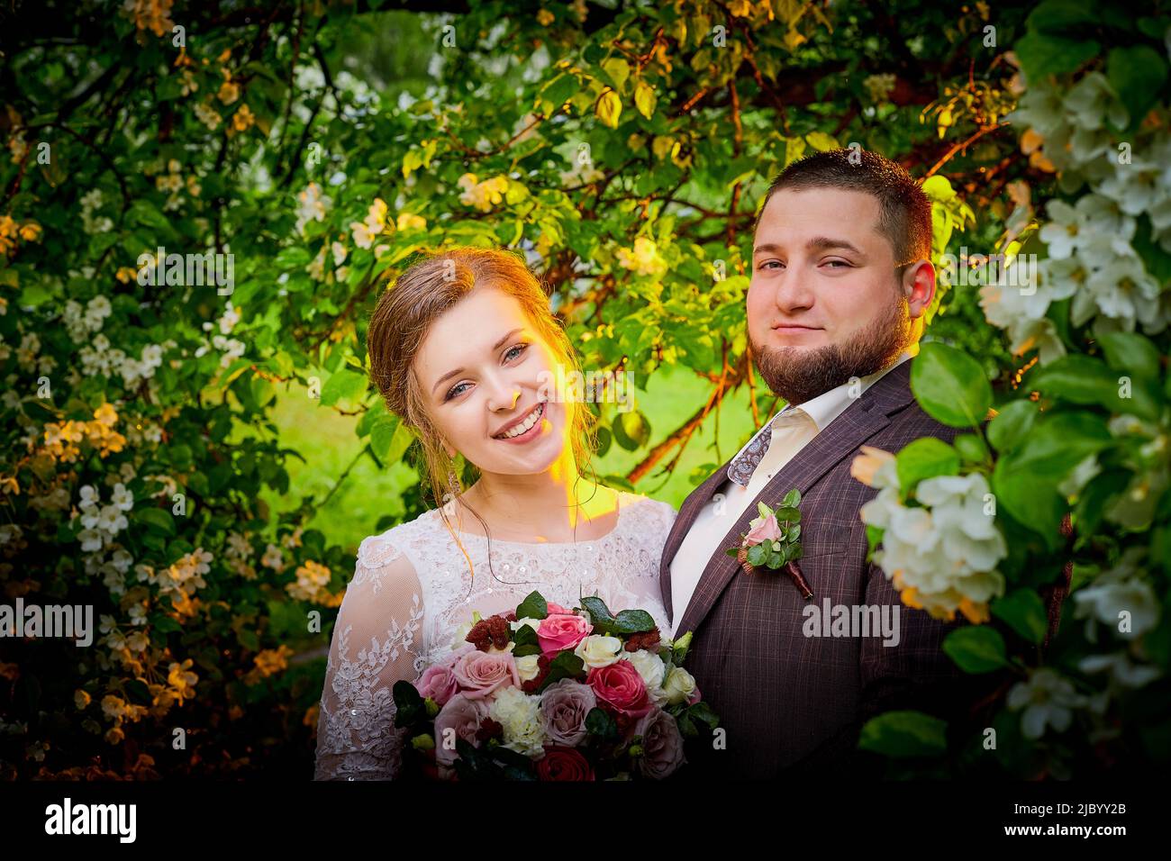 Concetto di matrimonio. Sposi e sposi nel parco verde in una giornata estiva Foto Stock