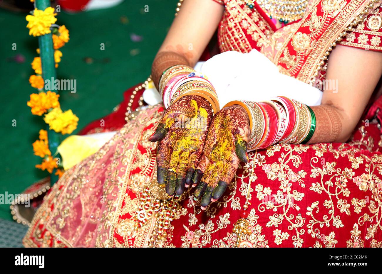 Una sposa indiana che mostra il design dei tatuaggi mehndi della sua mano Foto Stock