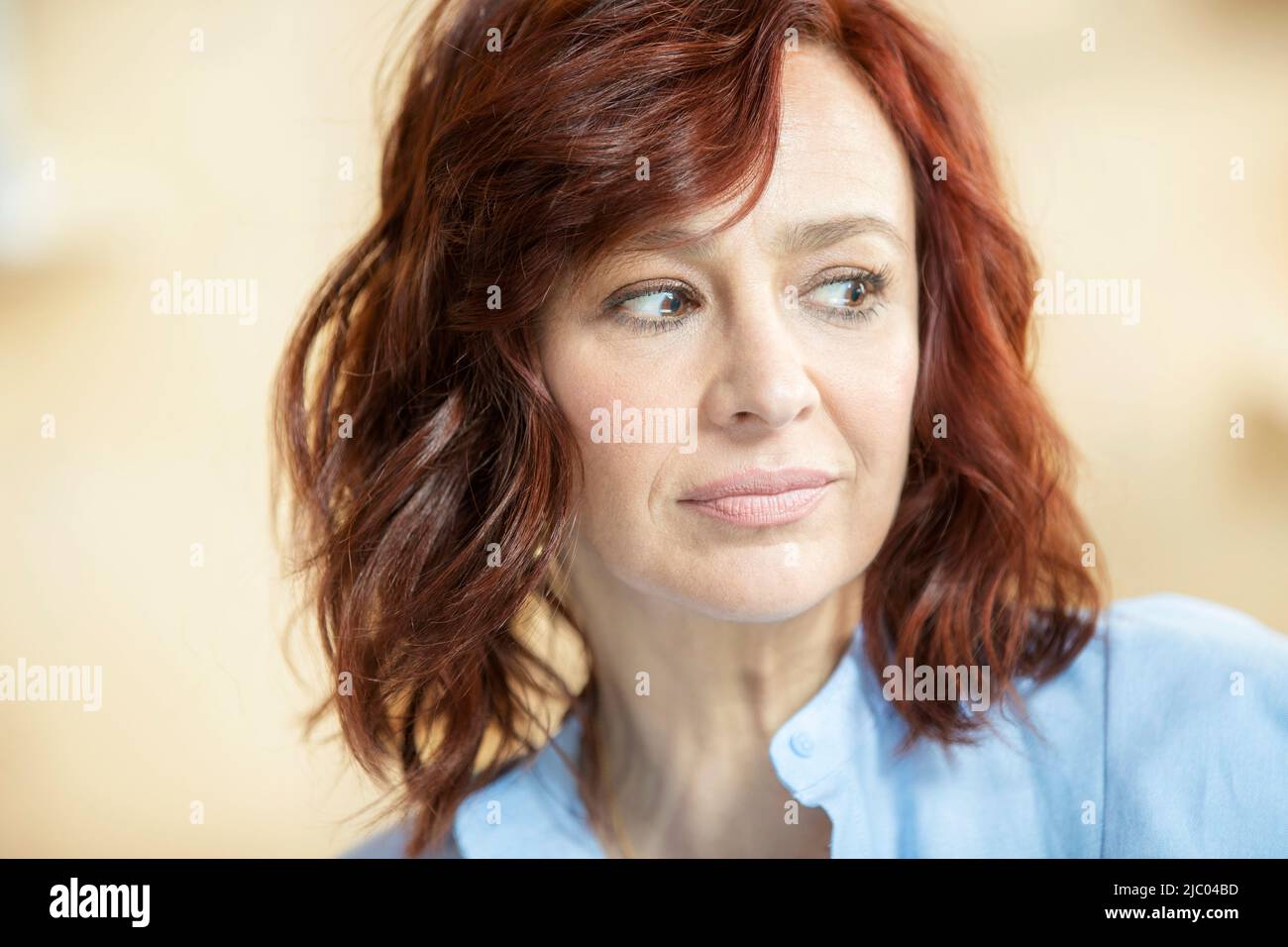 Primo piano ritratto di donna con testa rossa guardando fuori fotocamera. Foto Stock