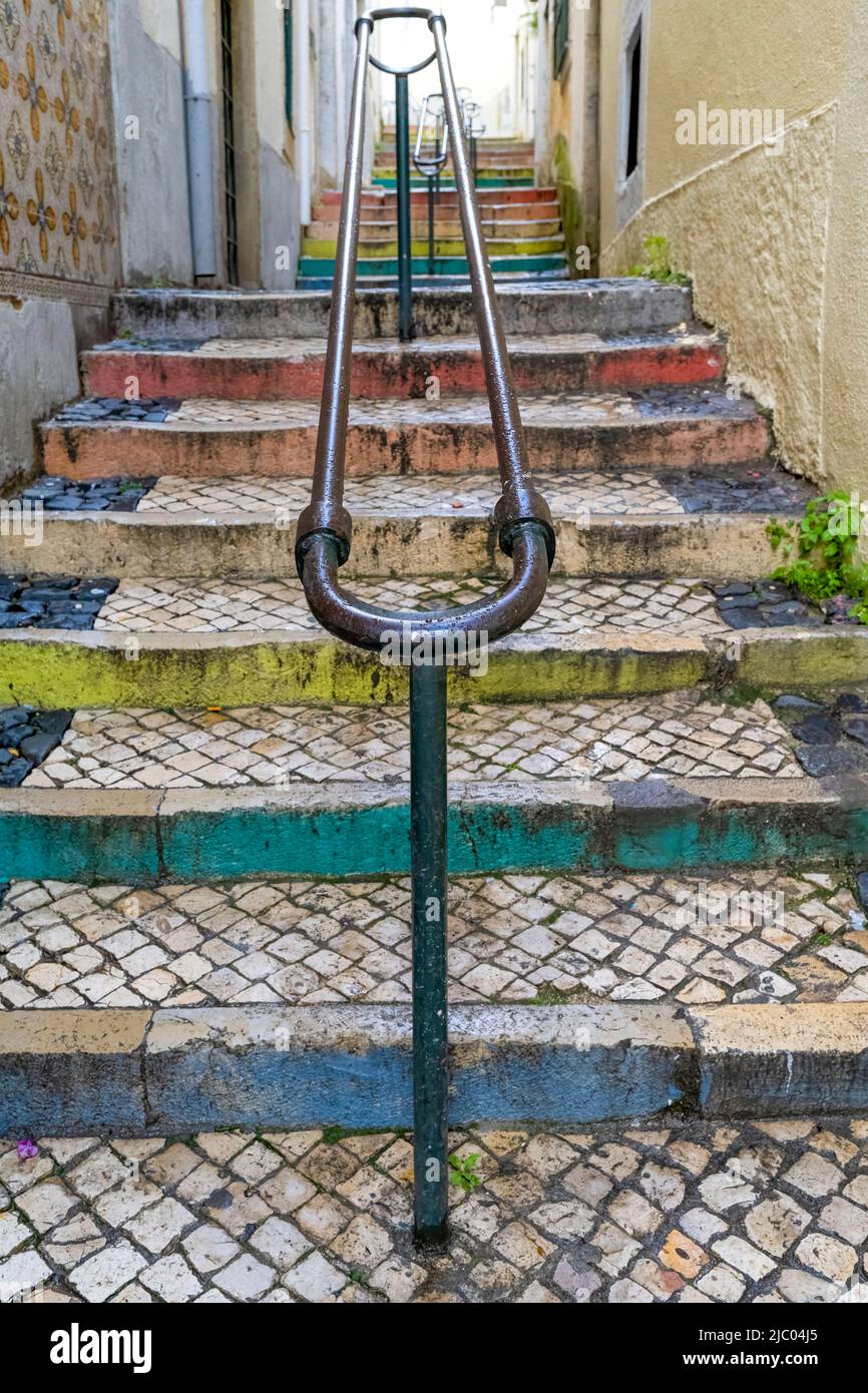 Una scalinata di ciottoli, bordata in Pride Colors, situata tra due case nel centro di Lisbona, capitale del Portogallo Foto Stock
