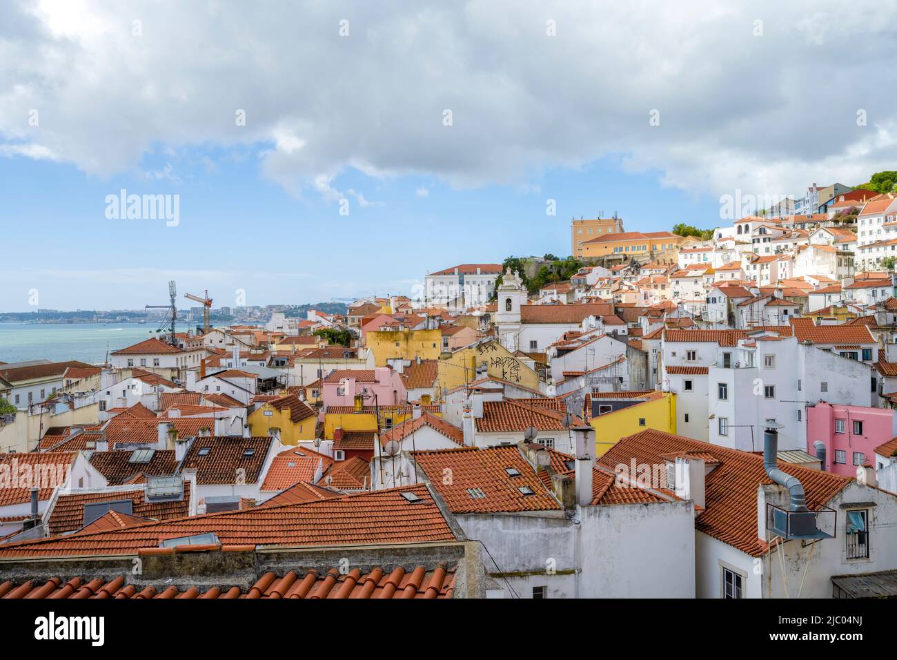 Vista sui tetti delle case nel centro di Lisbona, capitale del Portogallo. Il fiume Tago è solo visibile in lontananza Foto Stock