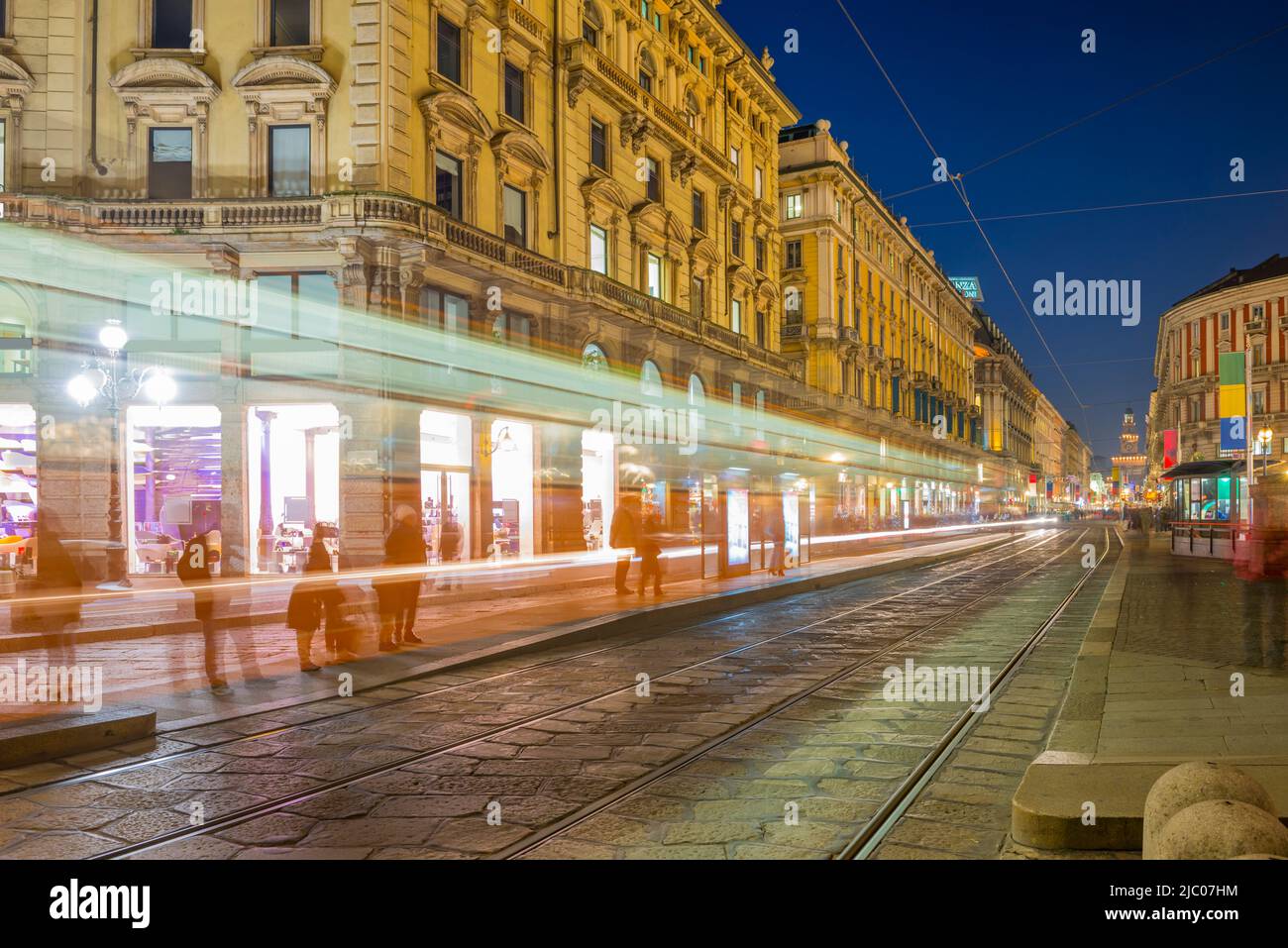 Paesaggio urbano con un tram a lunga esposizione al tramonto a Milano, Lombardia in Italia. Foto Stock