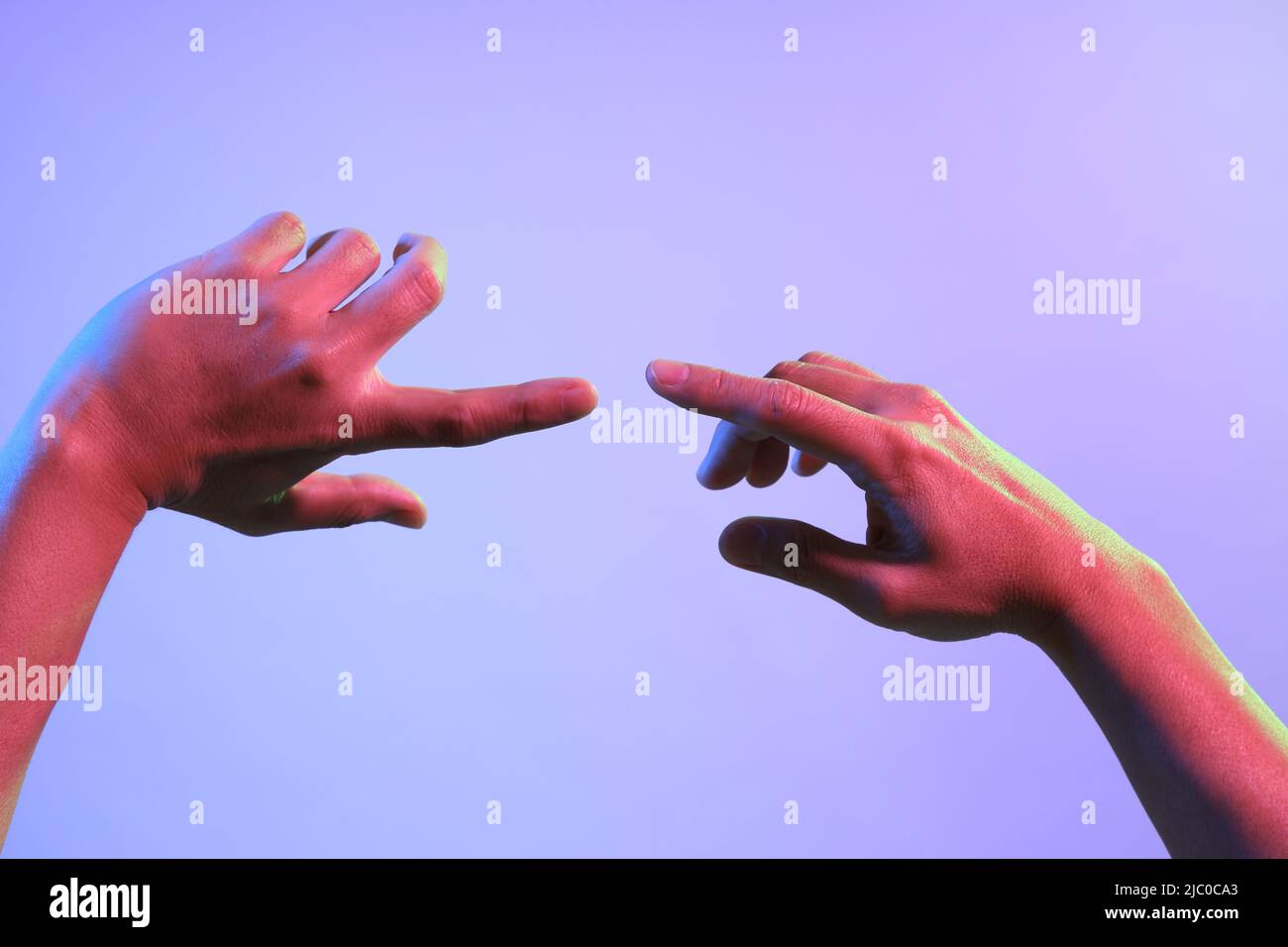 Le mani dell'uomo asiatico sotto il colore vivace si illuminano. Foto Stock