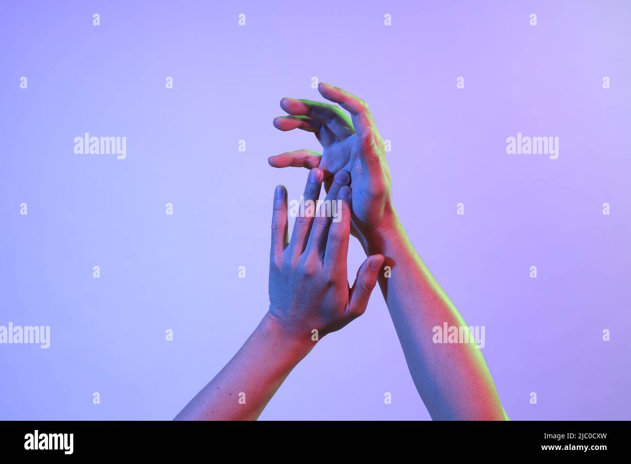Le mani dell'uomo asiatico sotto il colore vivace si illuminano. Foto Stock