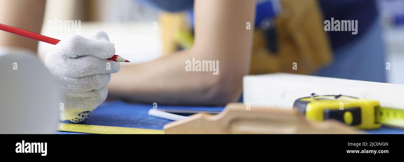 Donna operaio che fa correzioni nella pianificazione di costruzione con matita Foto Stock