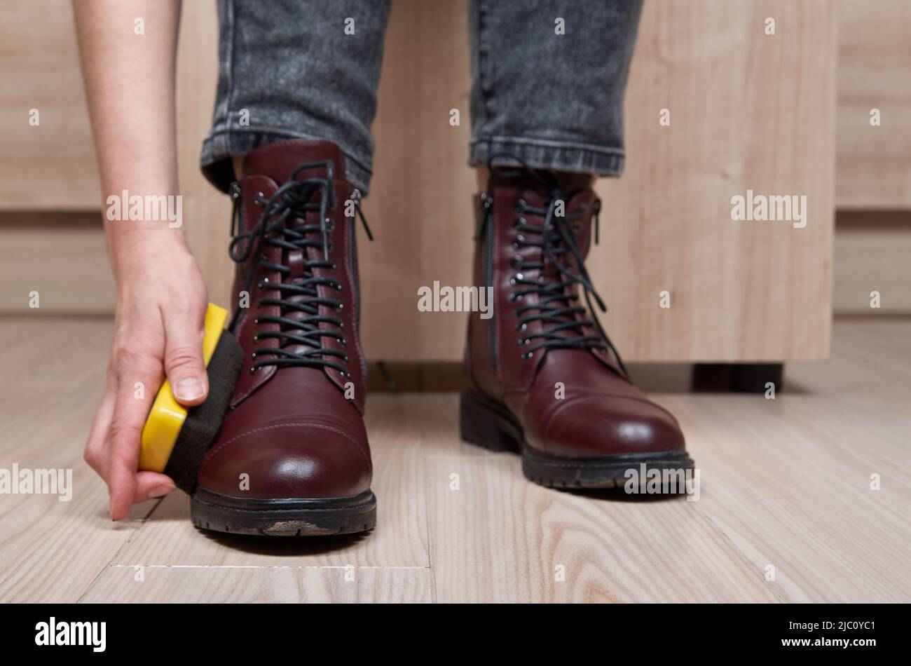 Donna che pulisce le proprie scarpe. Foto Stock