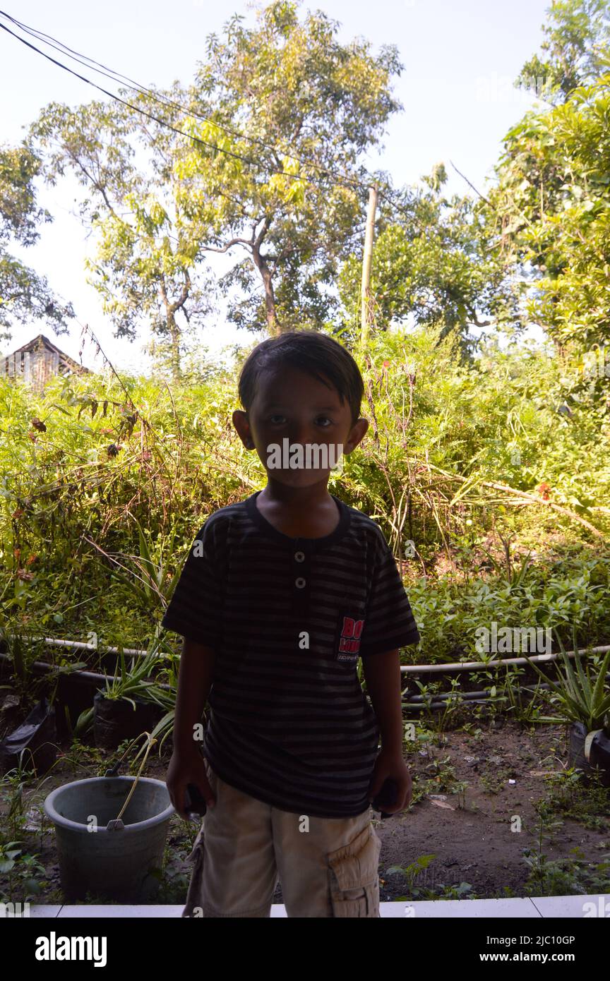 foto a luce bassa di un ragazzo che gioca di fronte alla casa Foto Stock