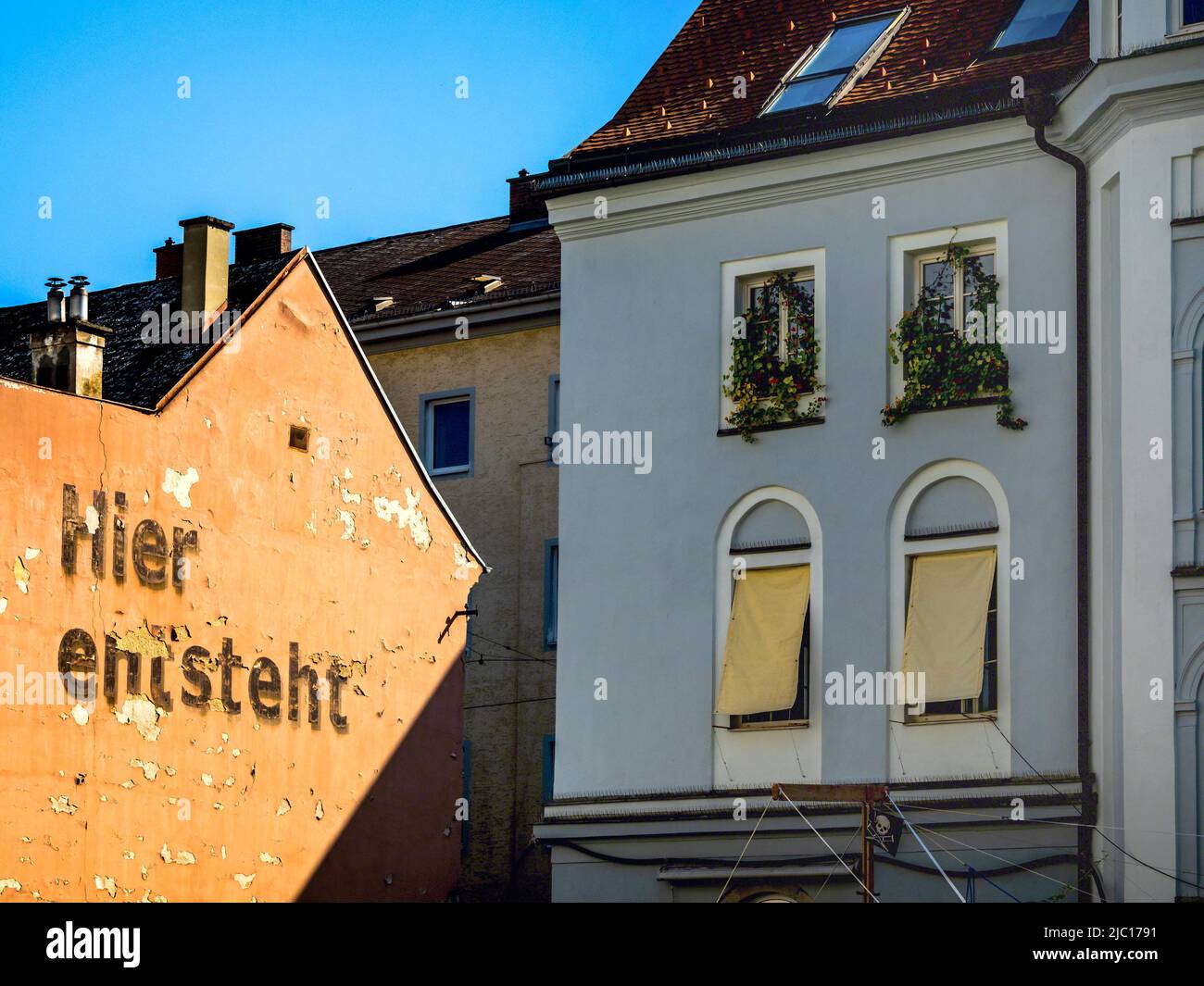 Scritta su una vecchia facciata casa 'qui sorge, hier entsteht', cantiere per un nuovo edificio residenziale nella città, Austria Foto Stock