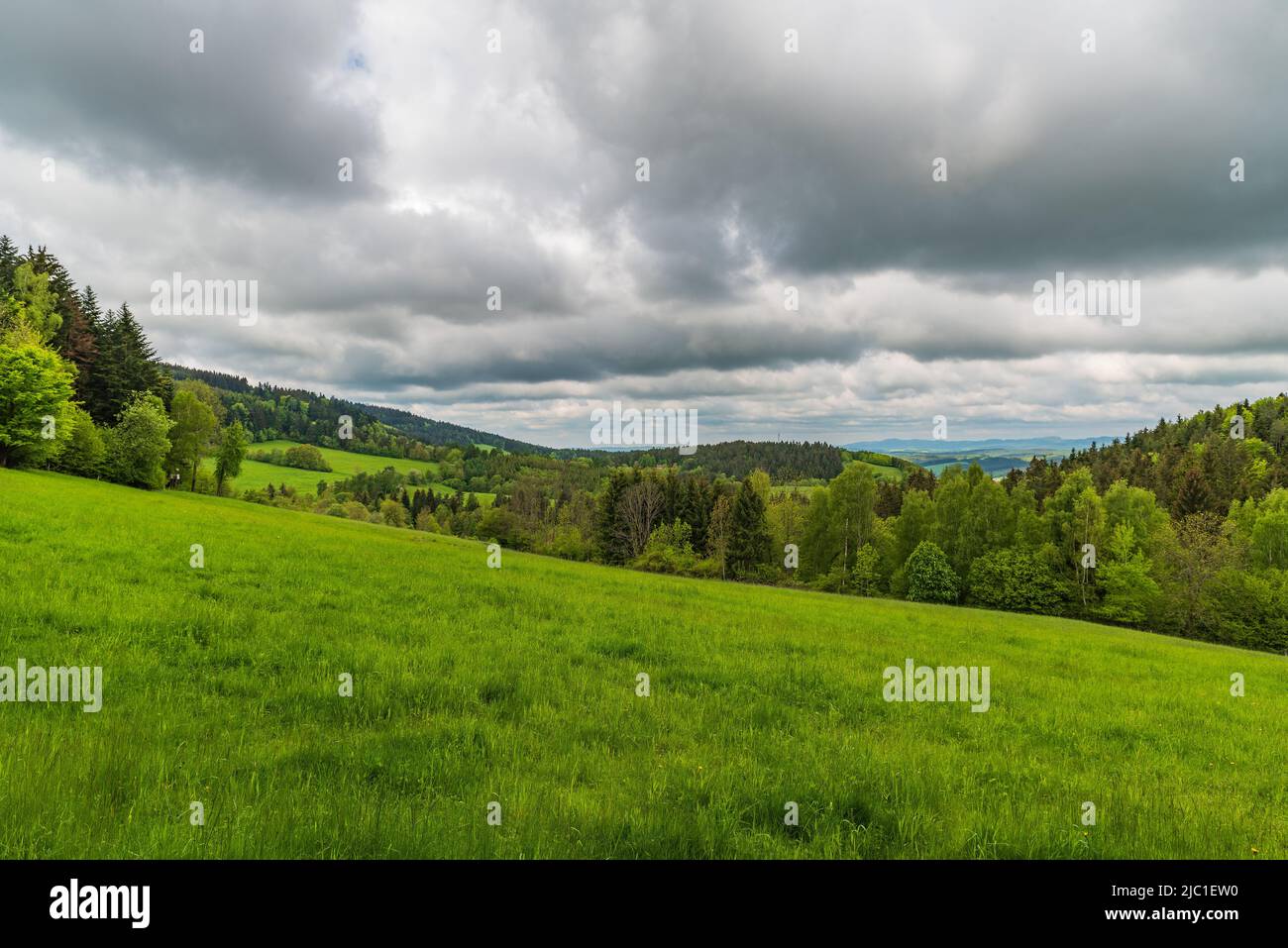 Primavera Bile Karpaty montagne con colline coperte da prati e foreste - vista sopra il villaggio di Strelna nella repubblica Ceca vicino confini con la Slovacchia Foto Stock