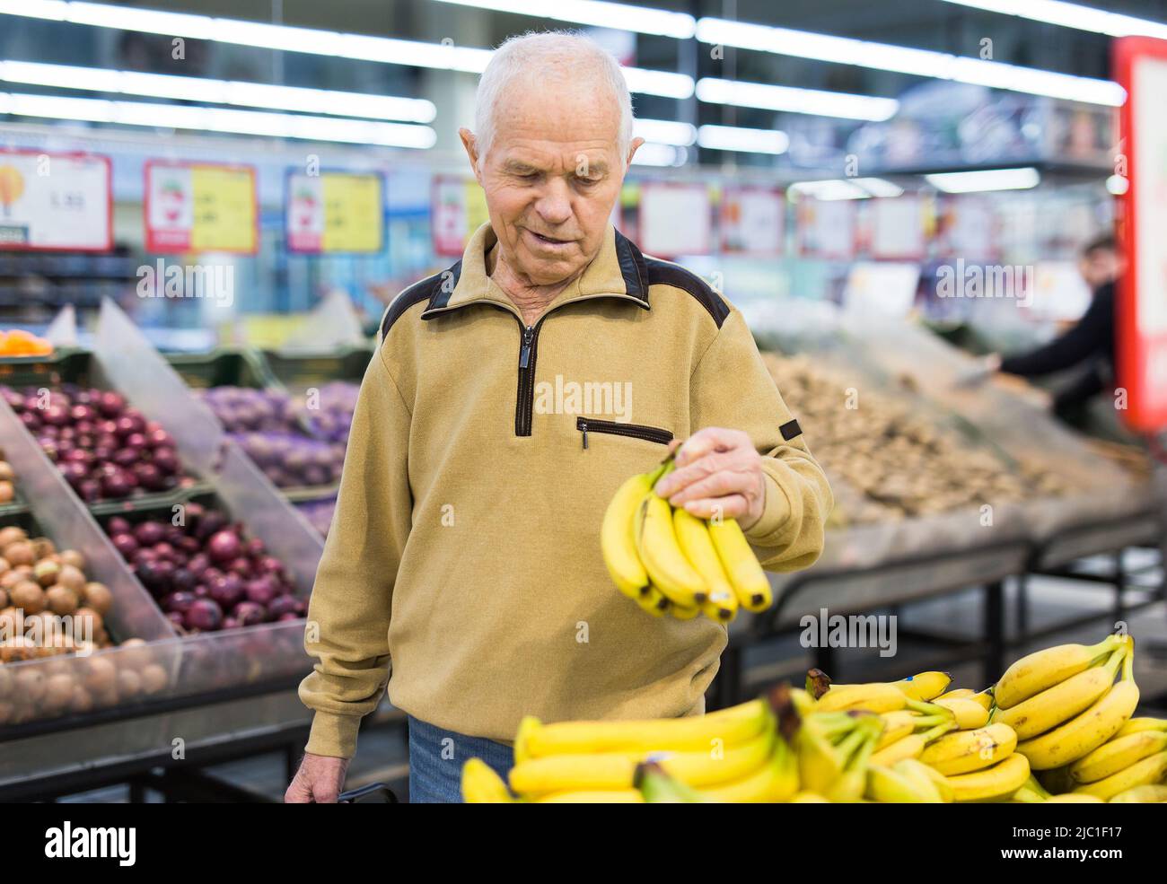 senor uomo pensionato che acquista banana in drogheria in supermercato Foto Stock