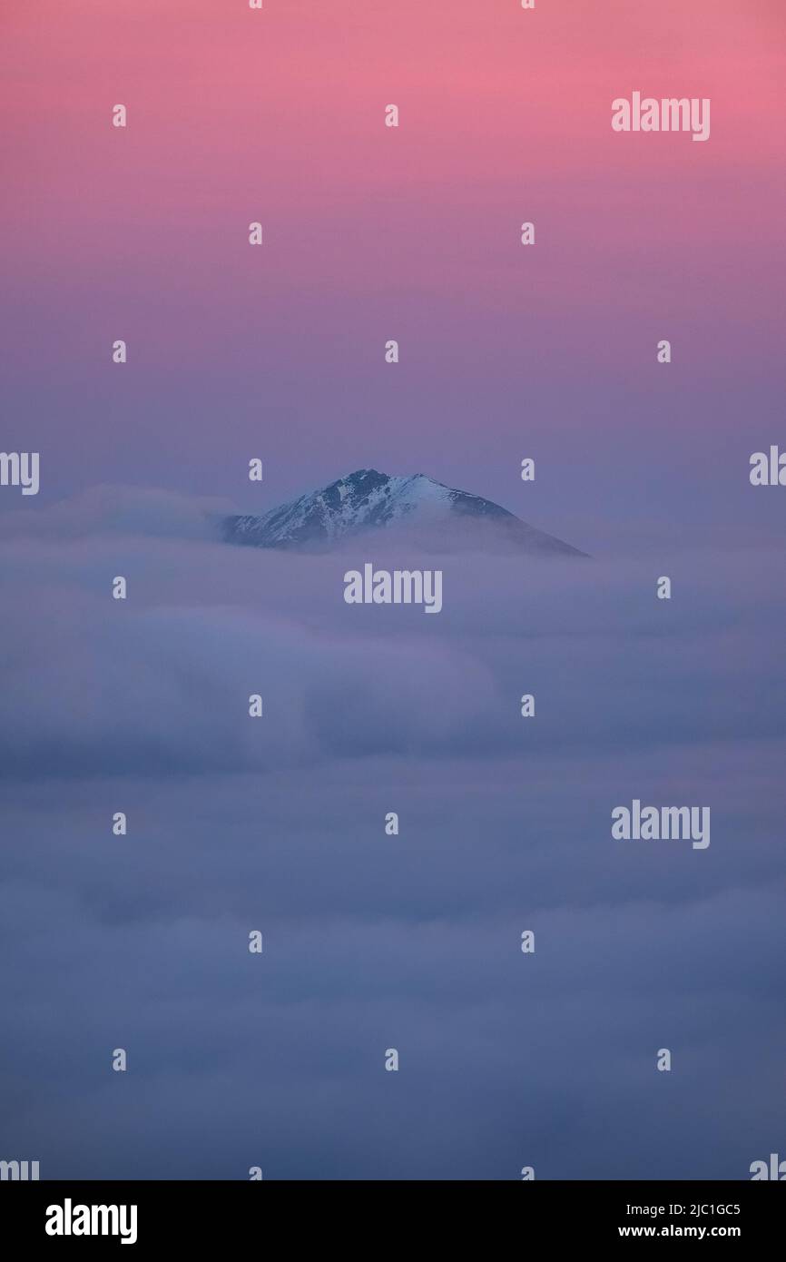Le Alpi Orobie al tramonto, avvolte nelle nuvole, durante una serata autunnale, nei pressi della città di Castione della presolana, Italia - Ottobre 2021. Foto Stock
