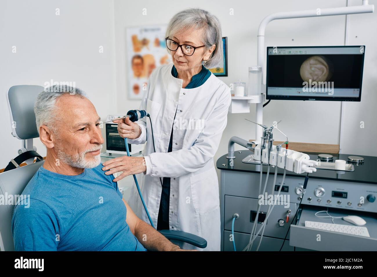 Endoscopia auricolare. ENT medico che esamina l'orecchio dell'uomo maturo usando l'endoscopio alla clinica otolaringologica Foto Stock