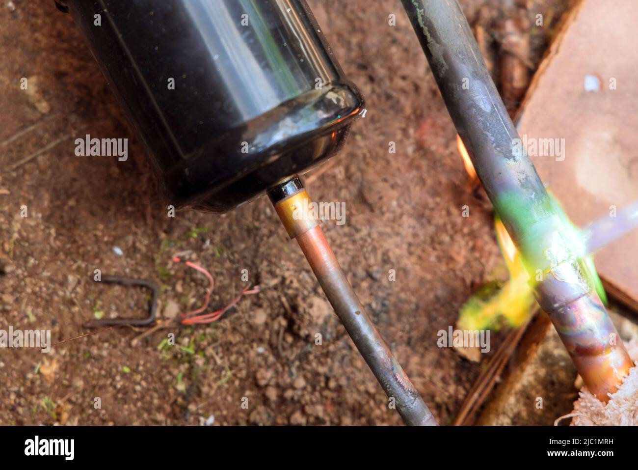 Il tecnico HVAC salda un giunto del tubo in rame per l'aria condizionata Foto Stock