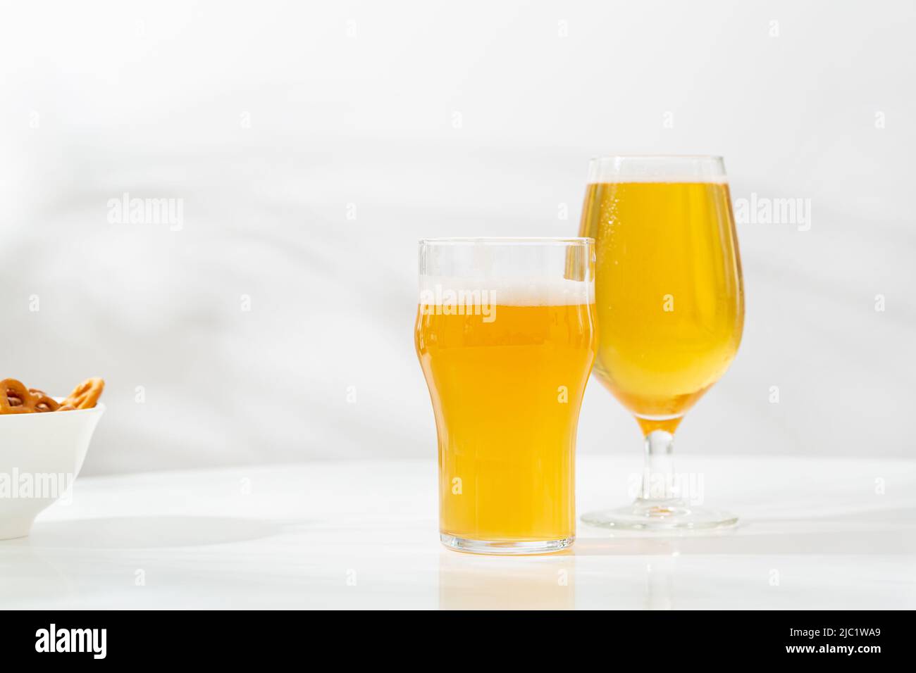 Due tazze con birra leggera su un tavolo leggero spazio copia snack artigianale Foto Stock