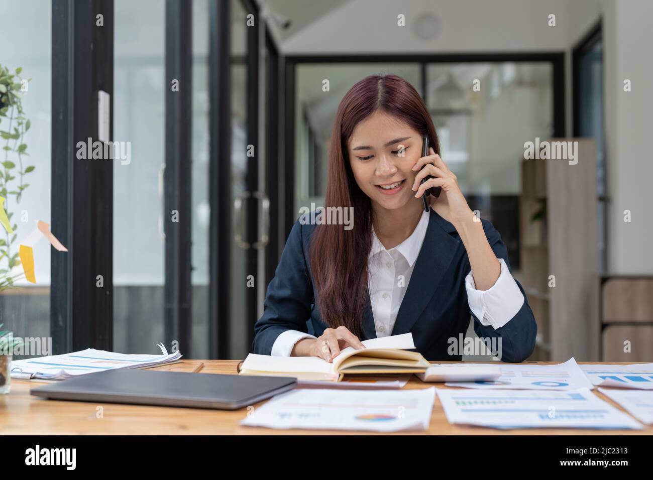 Marketing Sales Manager consulenza cliente fare offerta di vendita parlare al telefono vicino al portatile in ufficio, uomo d'affari serio fare chiamata negoziazione Foto Stock