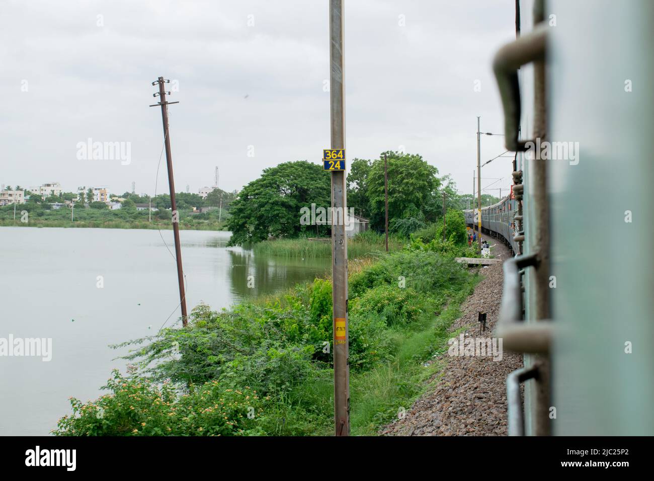 treno che passa vicino al lago e lato del treno è visibile. Foto Stock