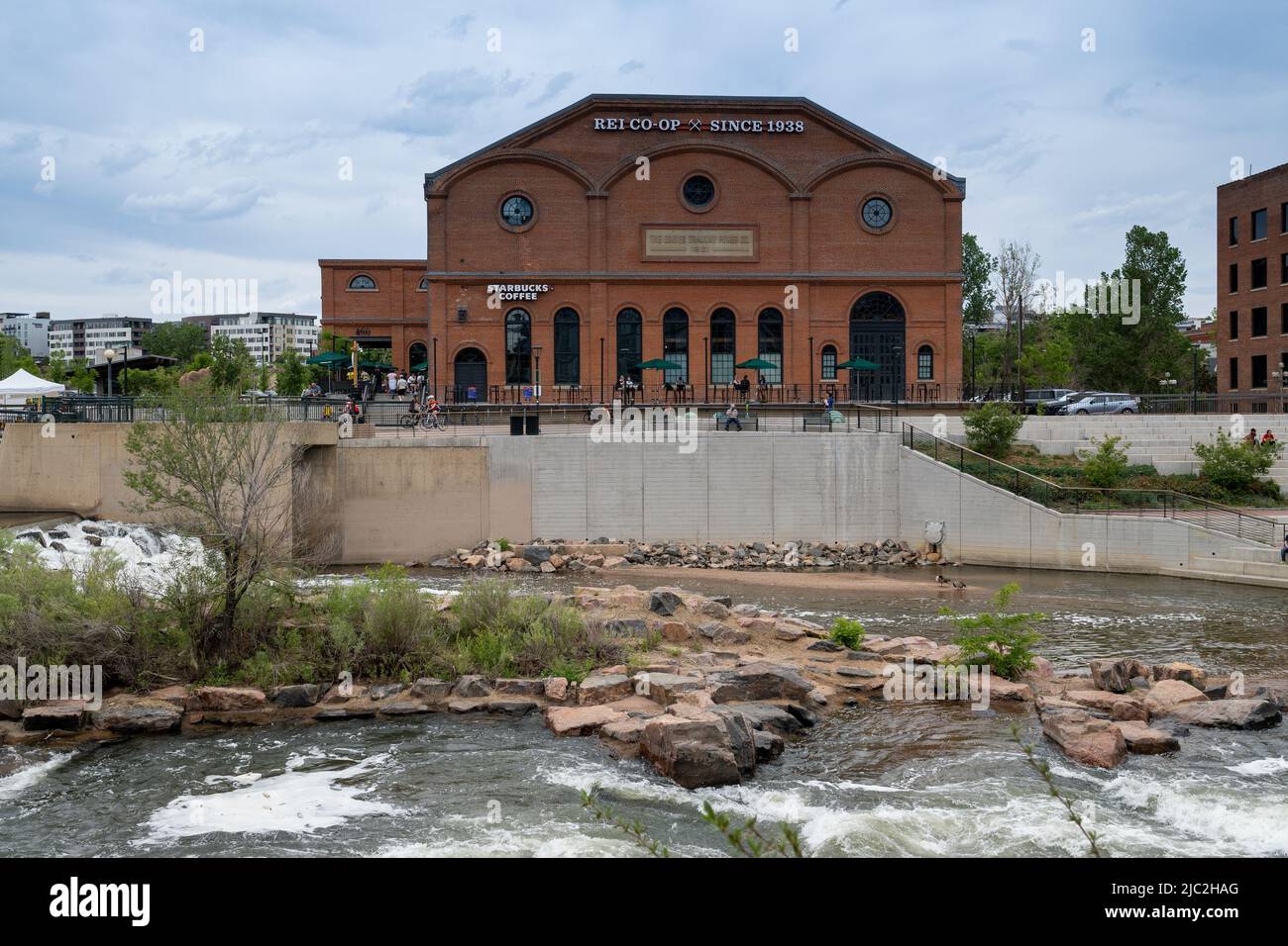 Denver, Colorado, 28 maggio 2022. Vista frontale dell'edificio storico REI e Starbucks lungo il South Platter River Trail, dall'altra parte del fiume Foto Stock