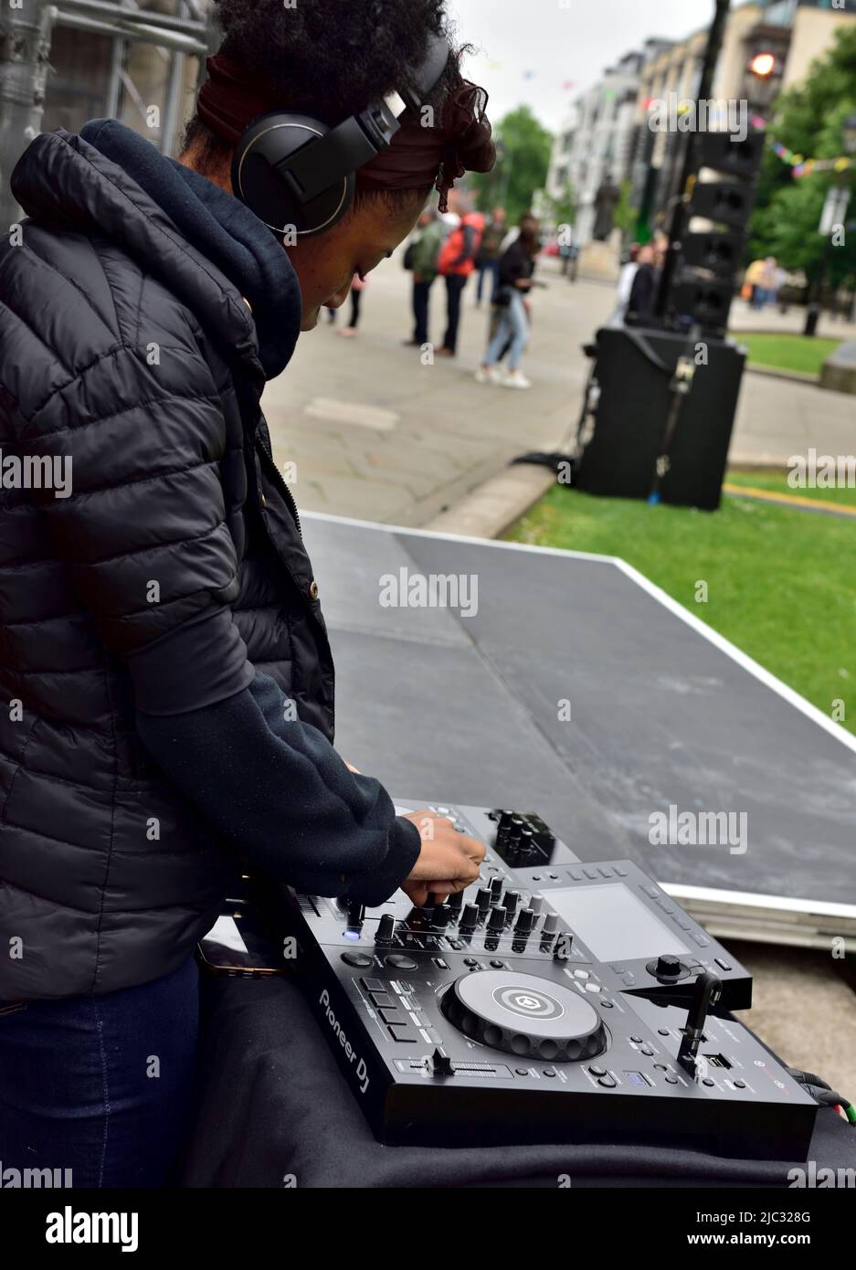 DJ che utilizza il deck di mixaggio del suono Pioneer per eventi all'aperto Foto Stock