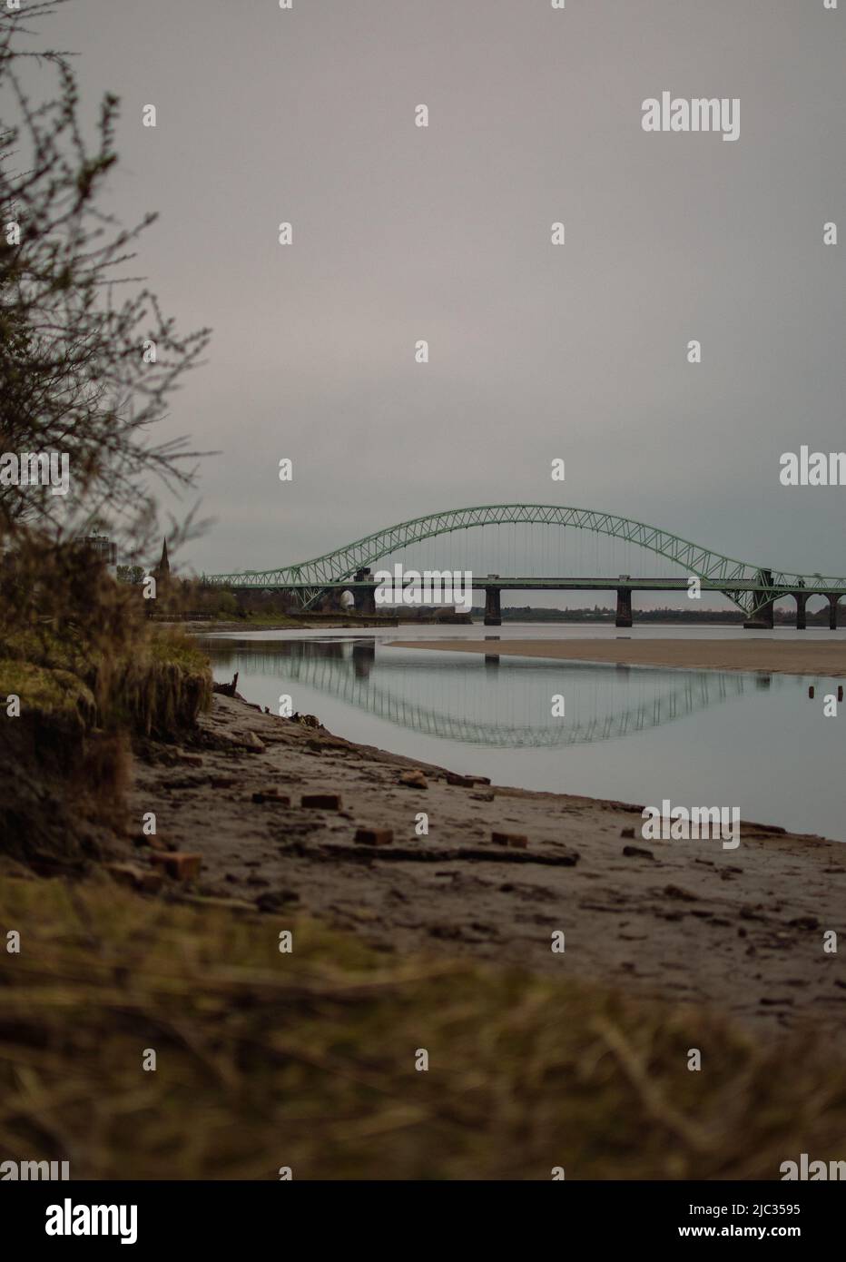 Naufragio sulla spiaggia sabbiosa, Wigg Island, con il Runcorn Bridge / Silver Jubilee Bridge sullo sfondo- Runcorn, Regno Unito. Foto Stock