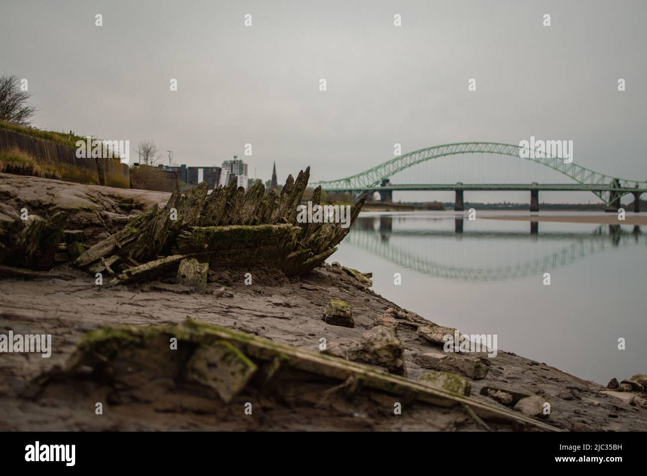 Naufragio sulla spiaggia sabbiosa, Wigg Island, con il Runcorn Bridge / Silver Jubilee Bridge sullo sfondo- Runcorn, Regno Unito. Foto Stock