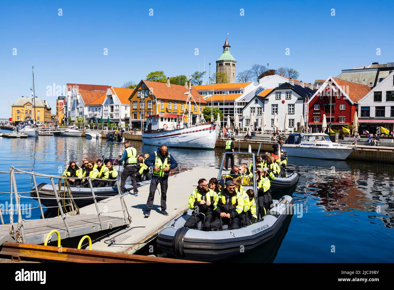 I passeggeri turistici imbarcarsi su imbarcazioni gommabili per un viaggio veloce sui fiordi. Tutti sono in Hi-viz Giacche.Stavanger, Norvegia Foto Stock