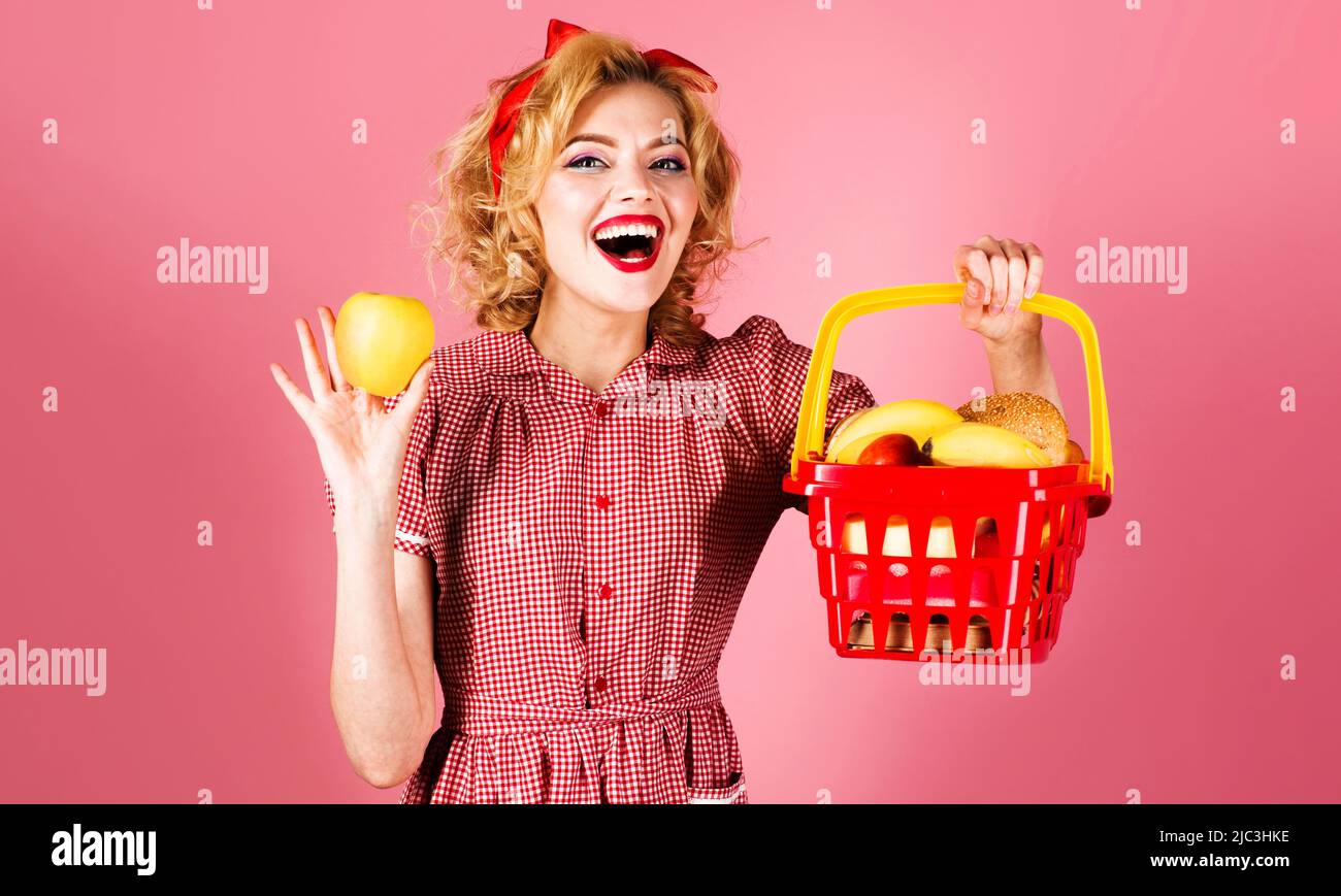 Donna felice con carrello pieno di generi alimentari tenere mela. Supermercato o negozio. Vendita. Sconto. Foto Stock