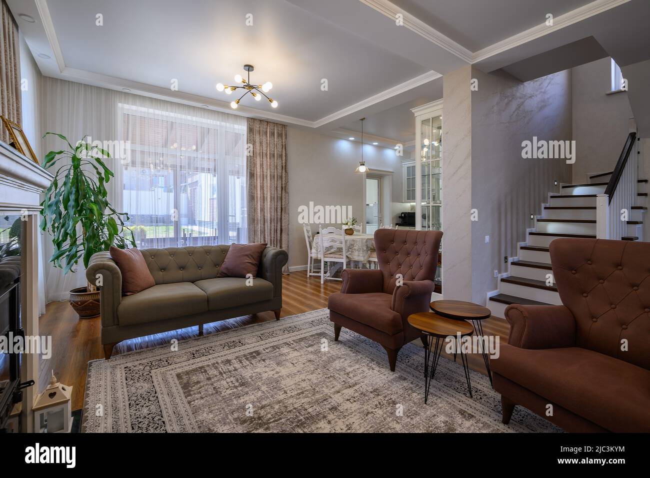 Appartamento monolocale con soggiorno con grande cucina bianca e tavolo da pranzo Foto Stock