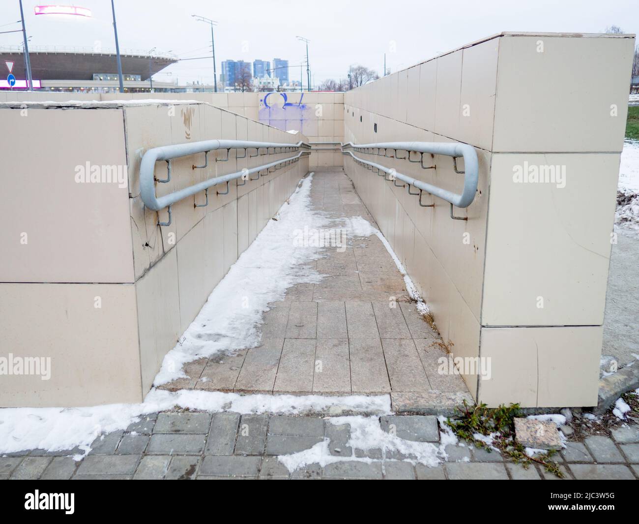 La discesa nella metropolitana è dotata di corrimano. Ingresso alla metropolitana per disabili e carrozzine. Principalmente nuvoloso. C'è neve Foto Stock