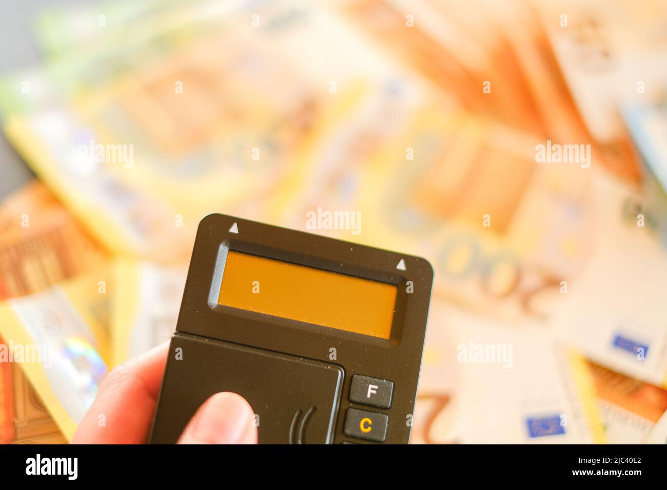 Pagamento con carta di credito.Shopping online. Pagare le fatture online. Le mani che inseriscono una carta di credito in un lettore di carte su sfondo euro fatture. Foto Stock