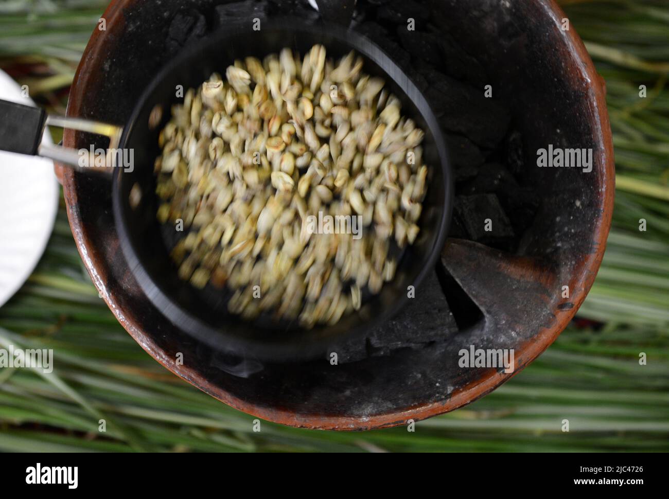 Tostatura dei chicchi di caffè in una tradizionale cerimonia del caffè etiope. Foto Stock